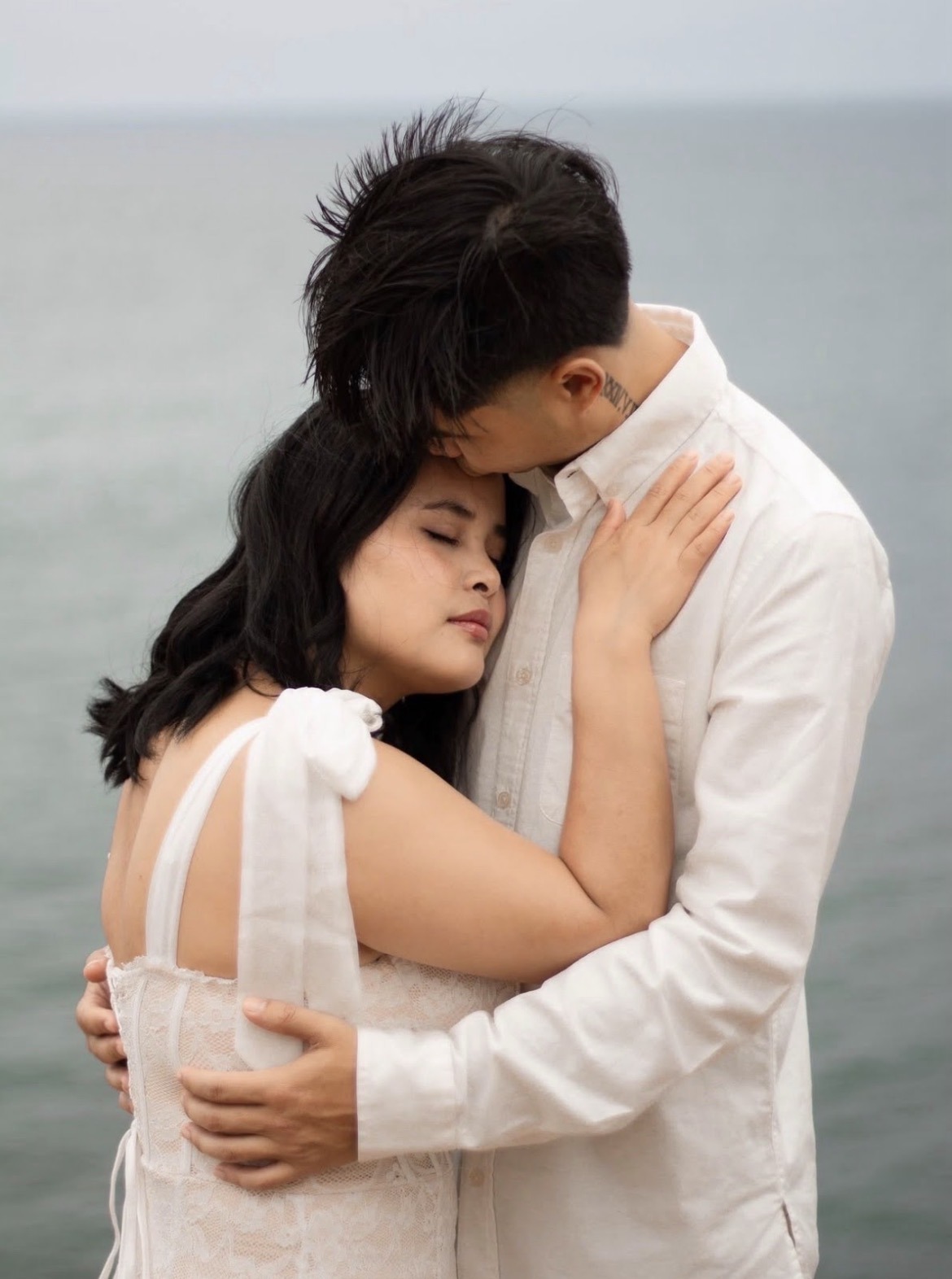 Couple embracing by the ocean in soft light